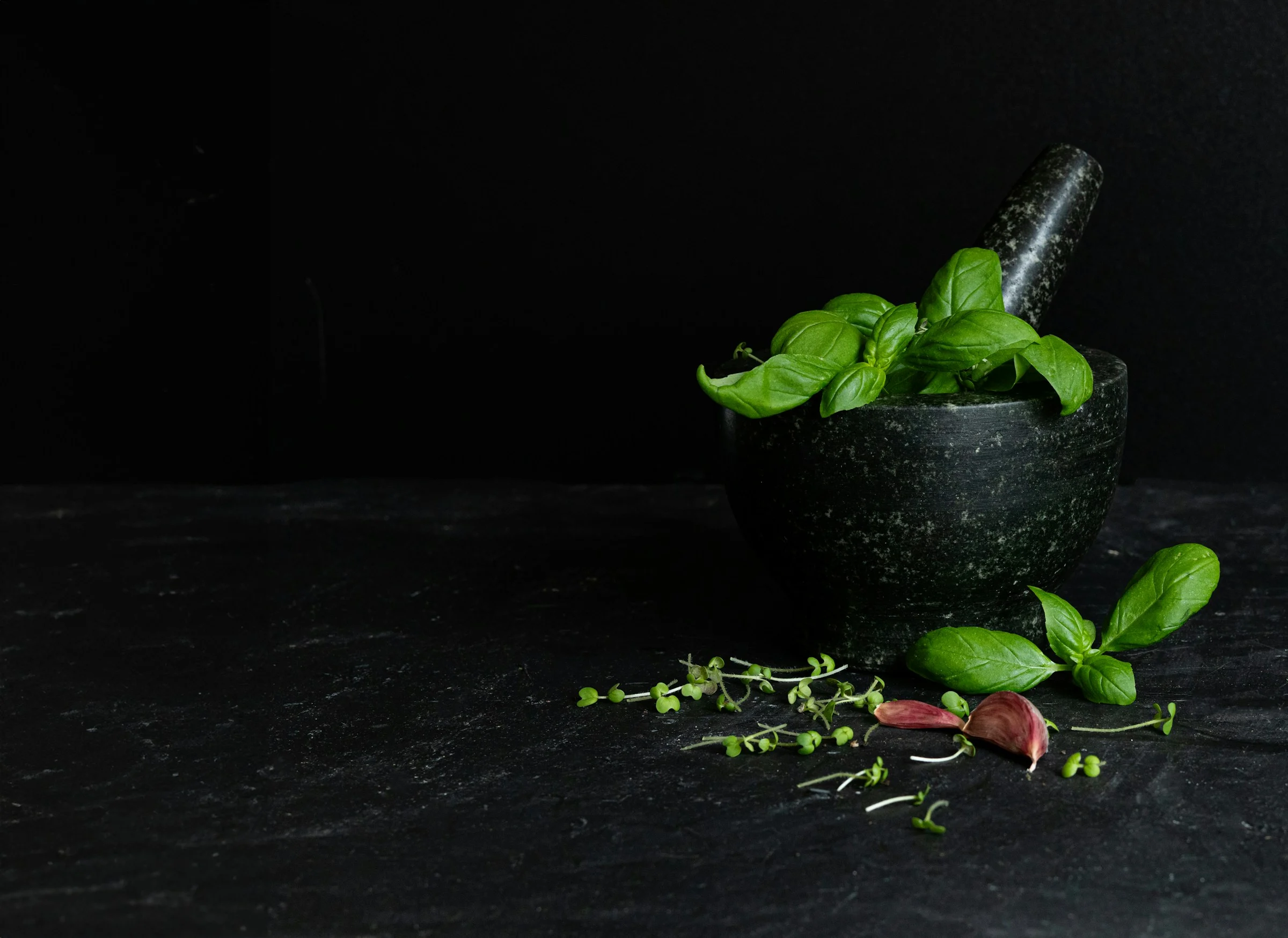 Mörser und Stößel mit Basilikum und Knoblauch Mörser und Stößel richtig verwenden