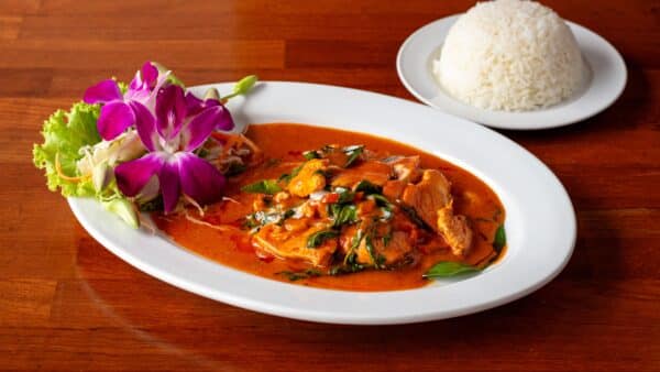 Rotes Thai-Curry mit Fleisch, Basilikum und Reis, zubereitet mit selbst gemachter roter Currypaste